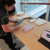 Girl looking through past copies of Aurora Literary Journal.