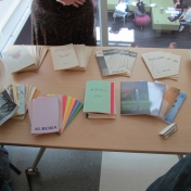 Nine decades of Aurora Literary Journal on a table for guests to look at.