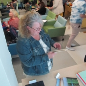 Guests mingle at Aurora launch Meet and Greet while one guest peruses archives.